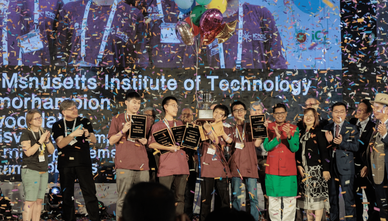 A group of students from MIT holding gold medals and a trophy on stage, surrounded by confetti, celebrating their championship win .