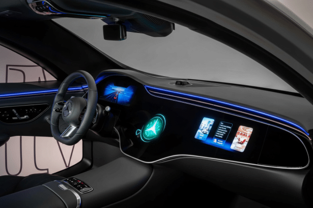 The interior of a modern car, showcasing a wide , luminous dashboard with multiple digital displays and ambient blue lighting .