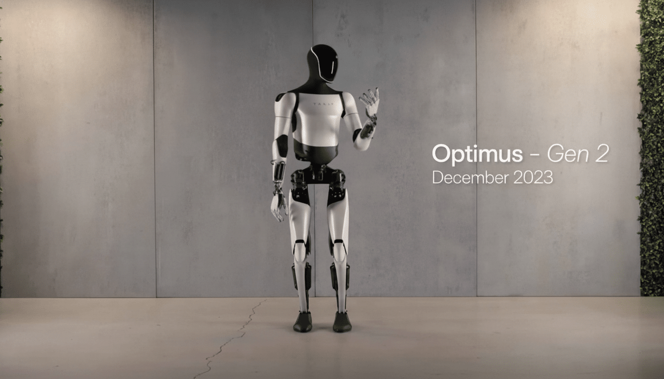 Tesla 's Optimus Gen 2 humanoid robot in a standing pose against a concrete wall with a plant wall on the right.