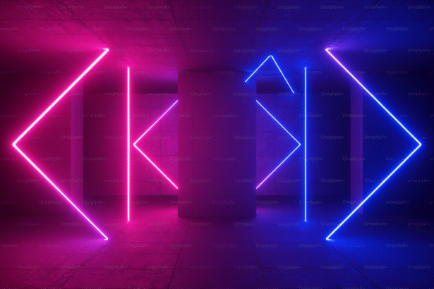 A dark room with pink and blue neon lights forming abstract geometric shapes on concrete walls, with the Unsplash+ watermark subtly repeated throughout .