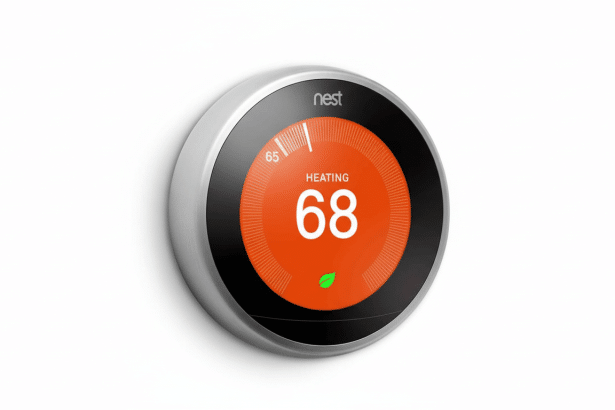 A Nest smart thermostat displaying HEATING 68 on an orange background , set against a clean white wall .