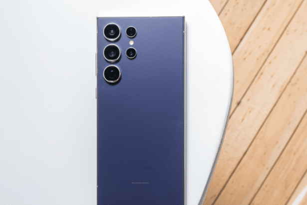 A professional shot of the back of a deep purple Samsung smartphone with multiple camera lenses, presented on a white and wooden surface, resized to a 16:9 aspect ratio.