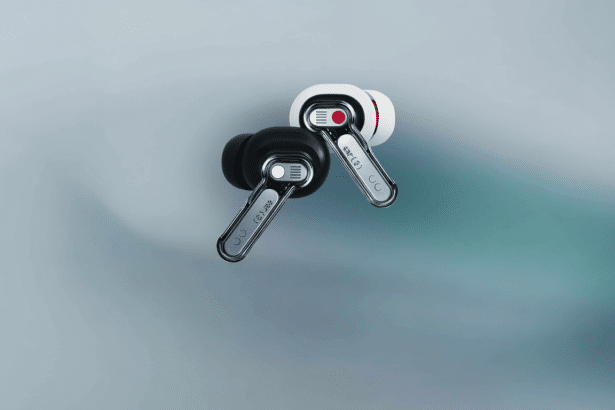 A professional shot of two Nothing Ear (1) earbuds, one black and one white, lying on a subtle gradient background.