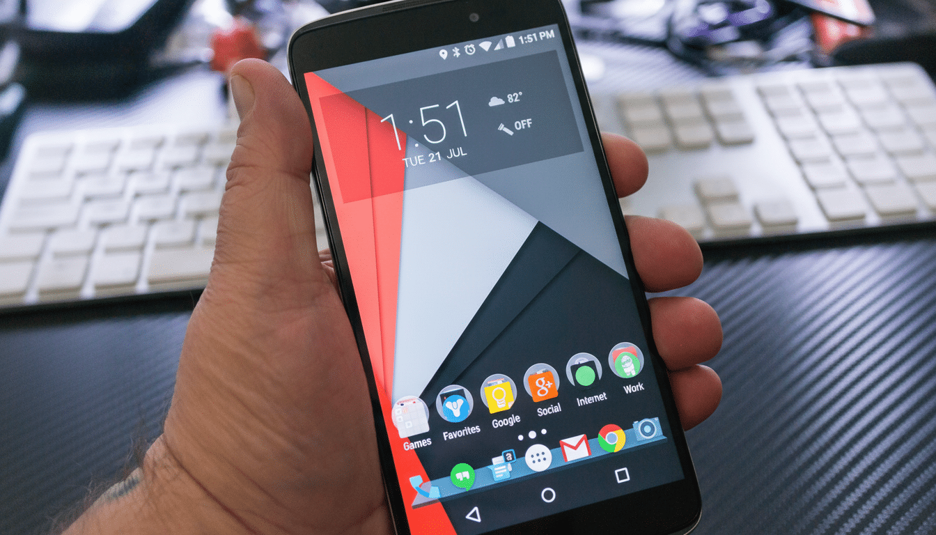 A hand holding a smartphone displaying the home screen with various app icons and the time.