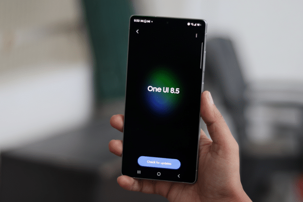 This image shows a close -up of a hand holding a smartphone displaying One UI 8 .5 and a Check f