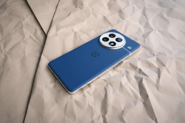 A blue OnePlus smartphone with a silver camera module resting on crumpled brown paper. Filename : oneplus phone brown paper.png