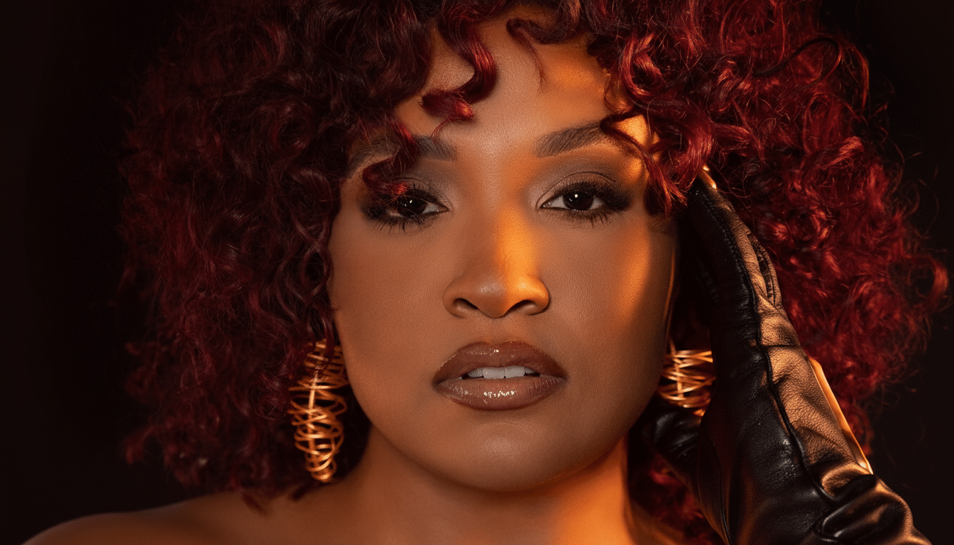 A professional head shot of a woman with red curly hair and gold earrings, wearing a black glove, against a dark background, resized to 1 6:9 aspect ratio. Filename : professional headshot womanred hair. png