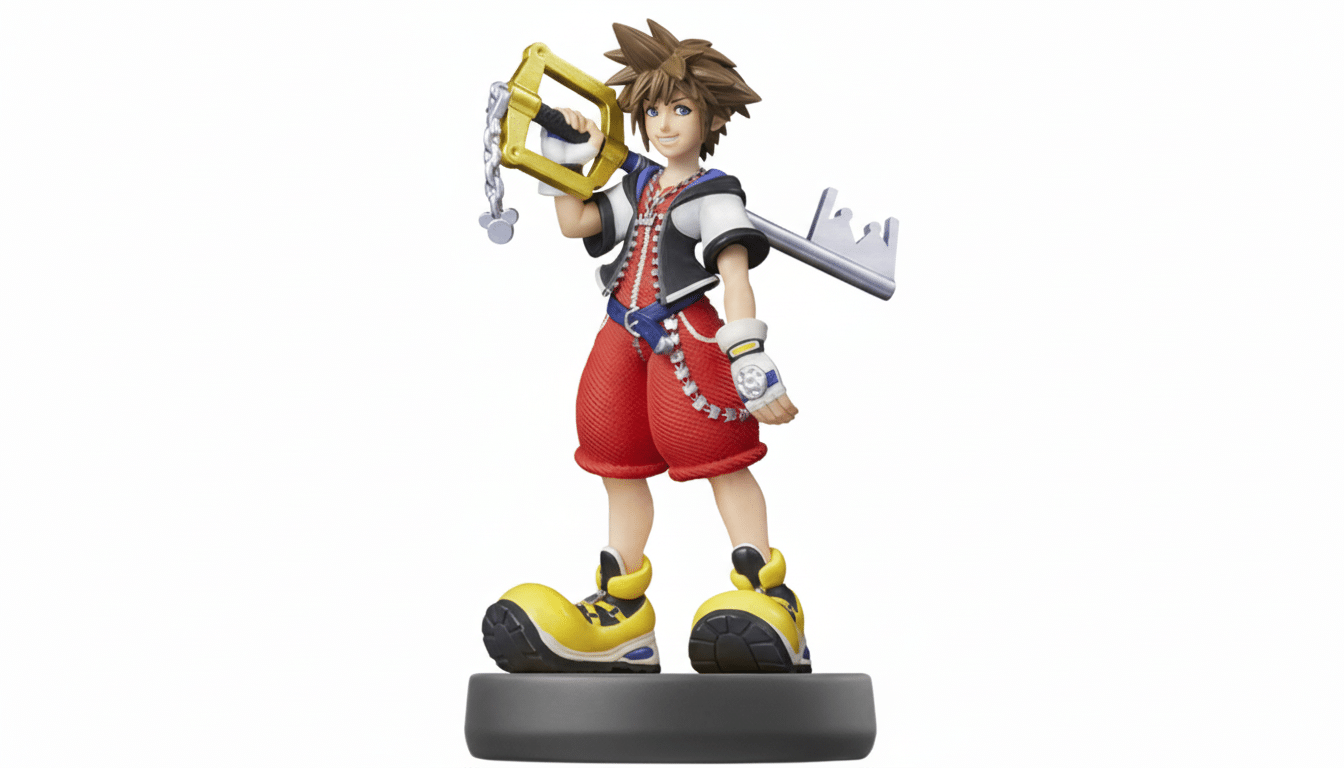 An Ami ibo figure of Sora from Kingdom Hearts, standing on a grey base, holding his Keyblade, against a white background. Filename : sora amiibo1 6x 9. png