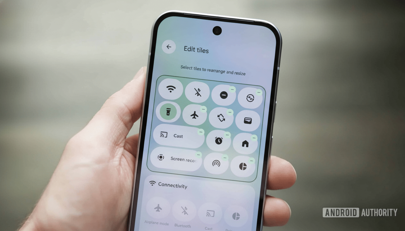 The user s hand holding a smartphone displaying the Edit tiles screen for quick settings. Filena