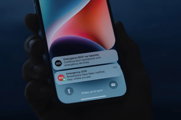 A hand holding a smartphone displaying two emergency SOS notifications via satellite.