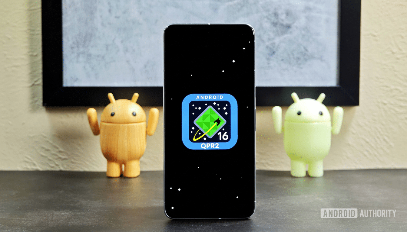 A smartphone displaying the Android 16 QPR 2 logo on a black screen, flanked by two Android figurines , set against a background with a framed picture. Filename : android1 6qpr 2smartphone . png