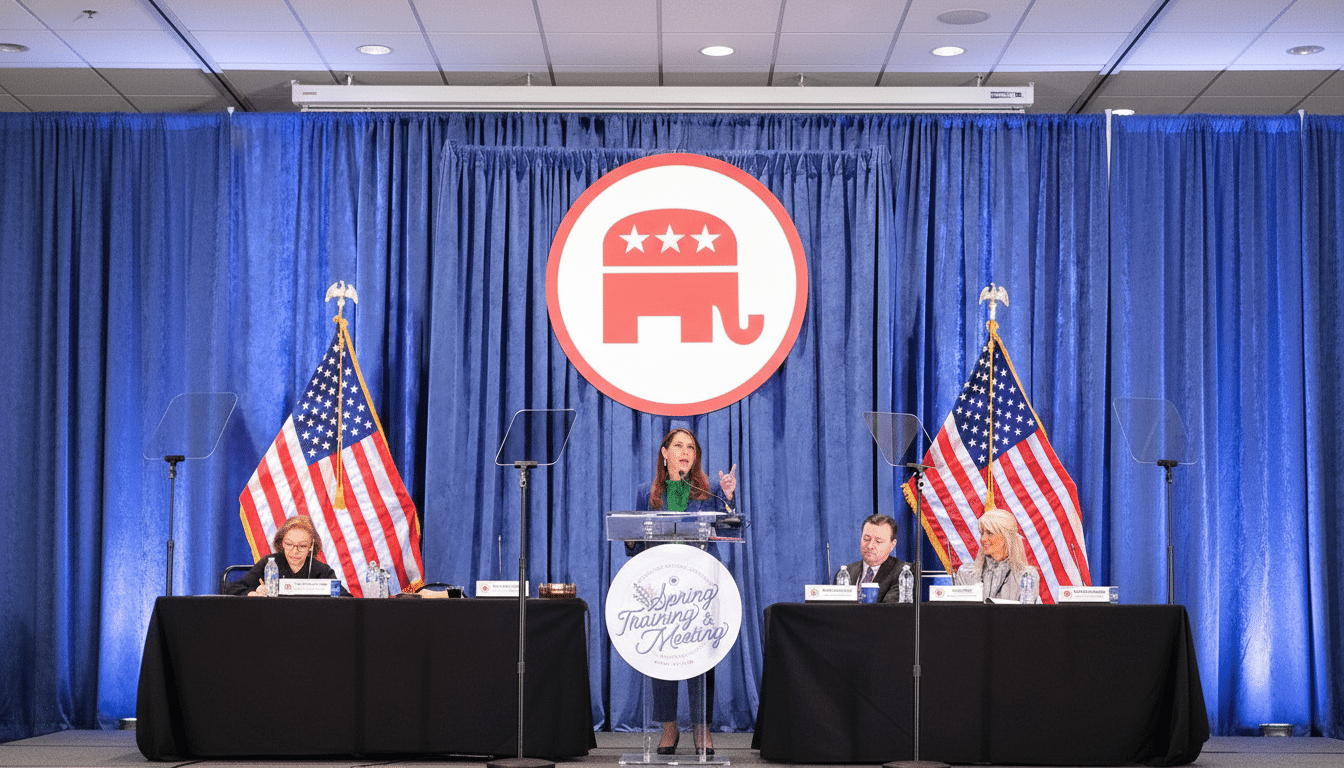 A woman speaks at a podium in front of a blue curtain with a Republican elephant logo, flanked by two American flags and seated panelists .