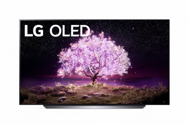 An LG OLED television displaying a vibrant image of a pink flowering tree at night with stars in the sky .