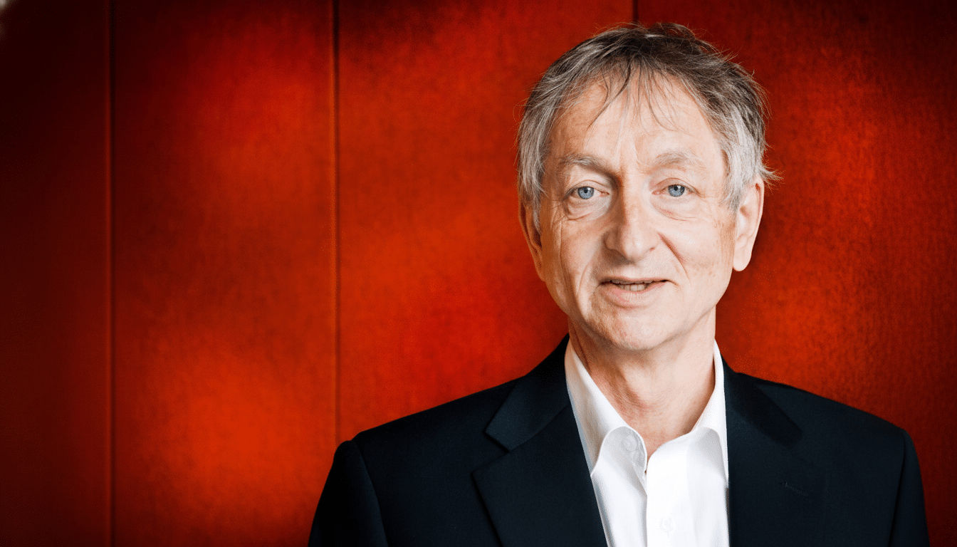 Professional head shot of a smiling man with grey hair and blue eyes, wearing a black suit jacket and white shirt , against a red background .