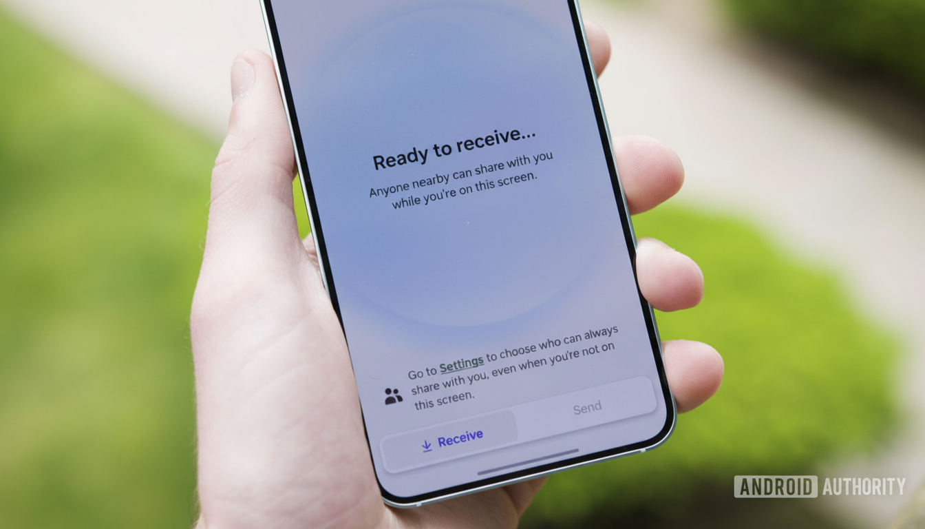 A hand holding a smartphone displaying a Ready to receive... screen with options to Receive or Send content.