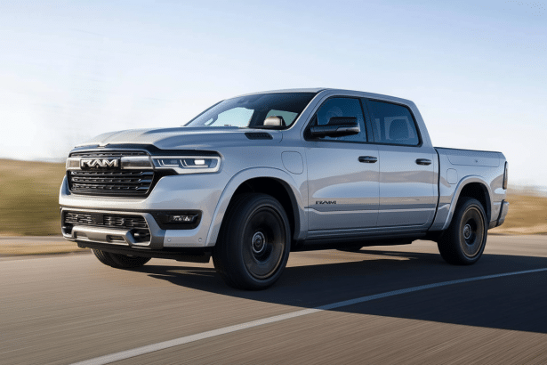 A professional , enhanced image of a light gray Ram 1 500 REV electric pickup truck driving on a road , resized to a 1 6:9 aspect ratio.