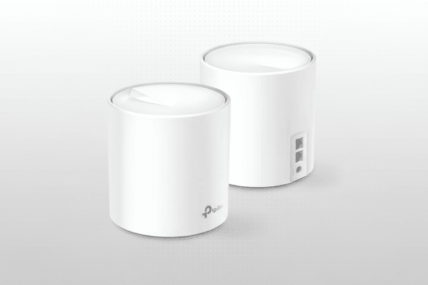 A professional image of two white cylindrical TP-Link Deco mesh Wi-Fi units on a subtle grey background with a dotted pattern.