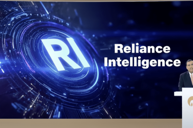 A man in a suit stands behind a podium, presenting in front of a large screen displaying RI Reliance Intelligence with a futuristic blue circular graphic .