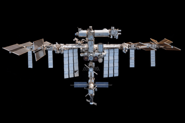 The International Space Station ( ISS) in Earth s orbit, with its array of solar panels and modules visible against the black ness of space.