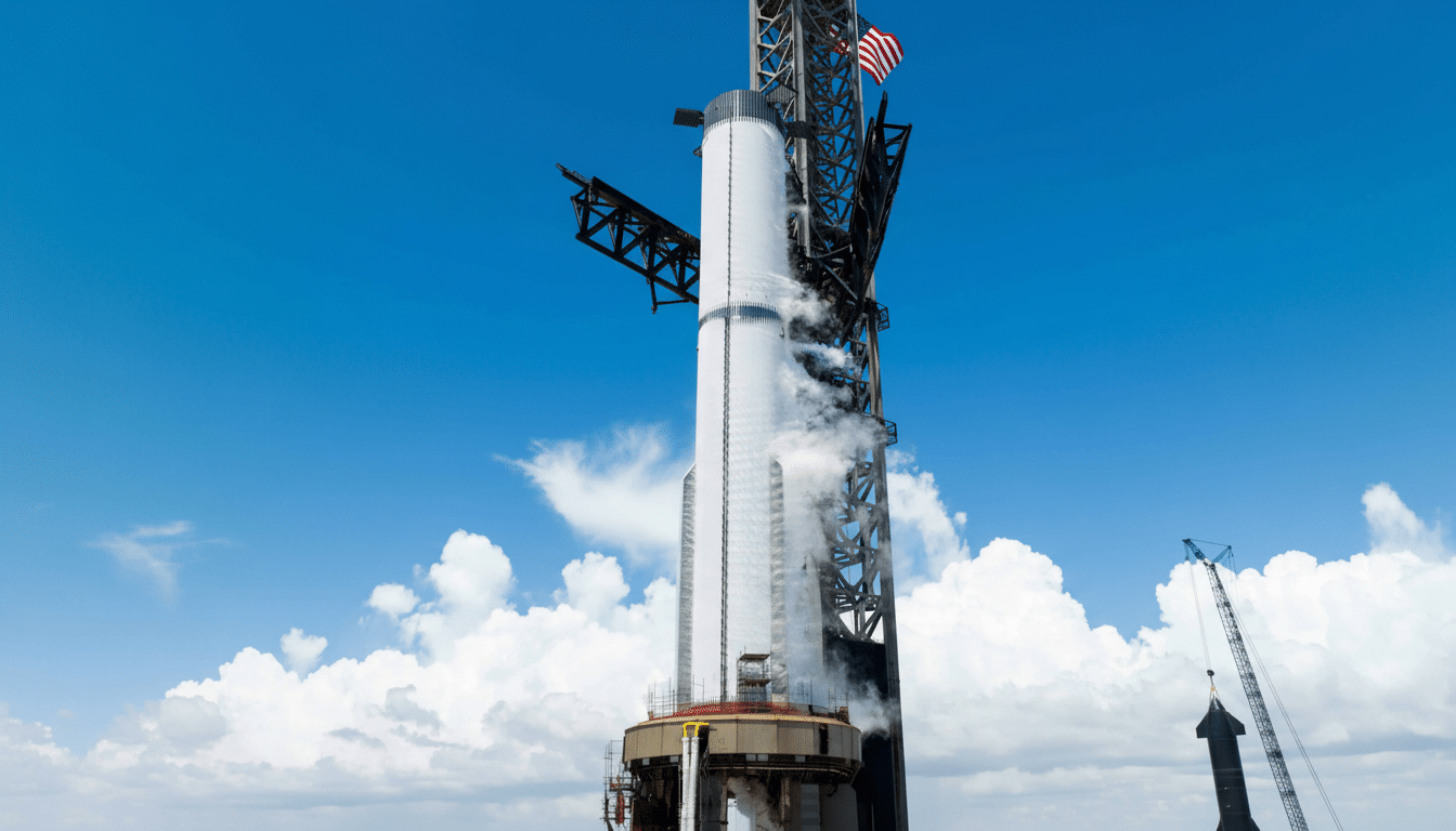 A large white rocket stands tall on a launchpad under a clear blue sky with white clouds. Smoke or vapor emanates from the rocket 's mid section, and an American flag is visible at the top of the launch tower structure. Another smaller rocket or structure is visible in the lower right.