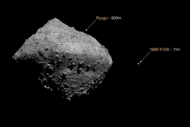 An image comparing the size of asteroid Ryugu, which is 90 0m across , with the much smaller asteroid 1 998 KY 26, which is 11 m across. Both asteroids are rocky and irregularly shaped, set against a black background. Filename : ryugu vs19 98ky 26comparison .png
