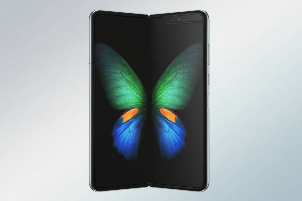 A Samsung Galaxy Fold smartphone, partially folded , displaying a butterfly image on its screen, set against a professional soft grey background with subtle geometric patterns.