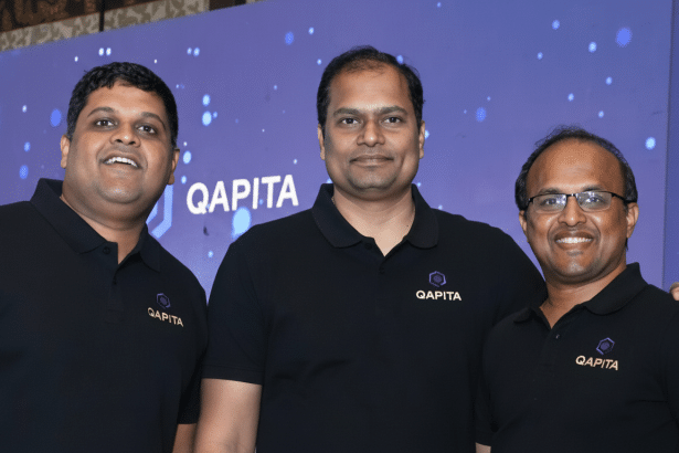 Three men wearing black Qap ita polo shirts stand in front of a blue background with the Q apita logo.