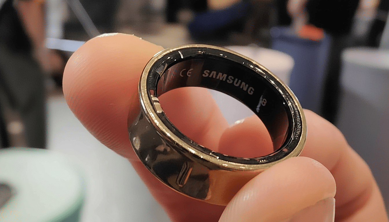 A gold Samsung Galaxy Ring worn on a person s finger, showcasing the SAMSUNG branding on the inside.