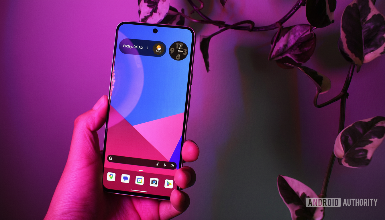 A hand holding a smartphone with a colorful geometric wallpaper and various app icons, set against a blurred background of green and white variegated plant leaves, illuminated by pink and purple light.