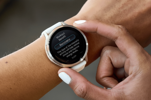 A close -up of a person's arm wearing a white smartwatch , with their finger touching the screen. The watch display shows Recovery under Workout Benefit and text describing low-intensity activity. Filename : smartwatchrecovery screen.png