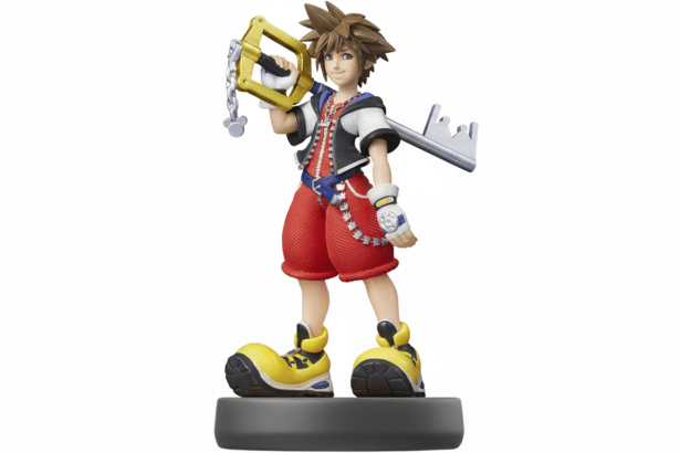 An Ami ibo figure of Sora from Kingdom Hearts, standing on a grey base, holding his Keyblade, against a white background. Filename : sora amiibo1 6x 9. png