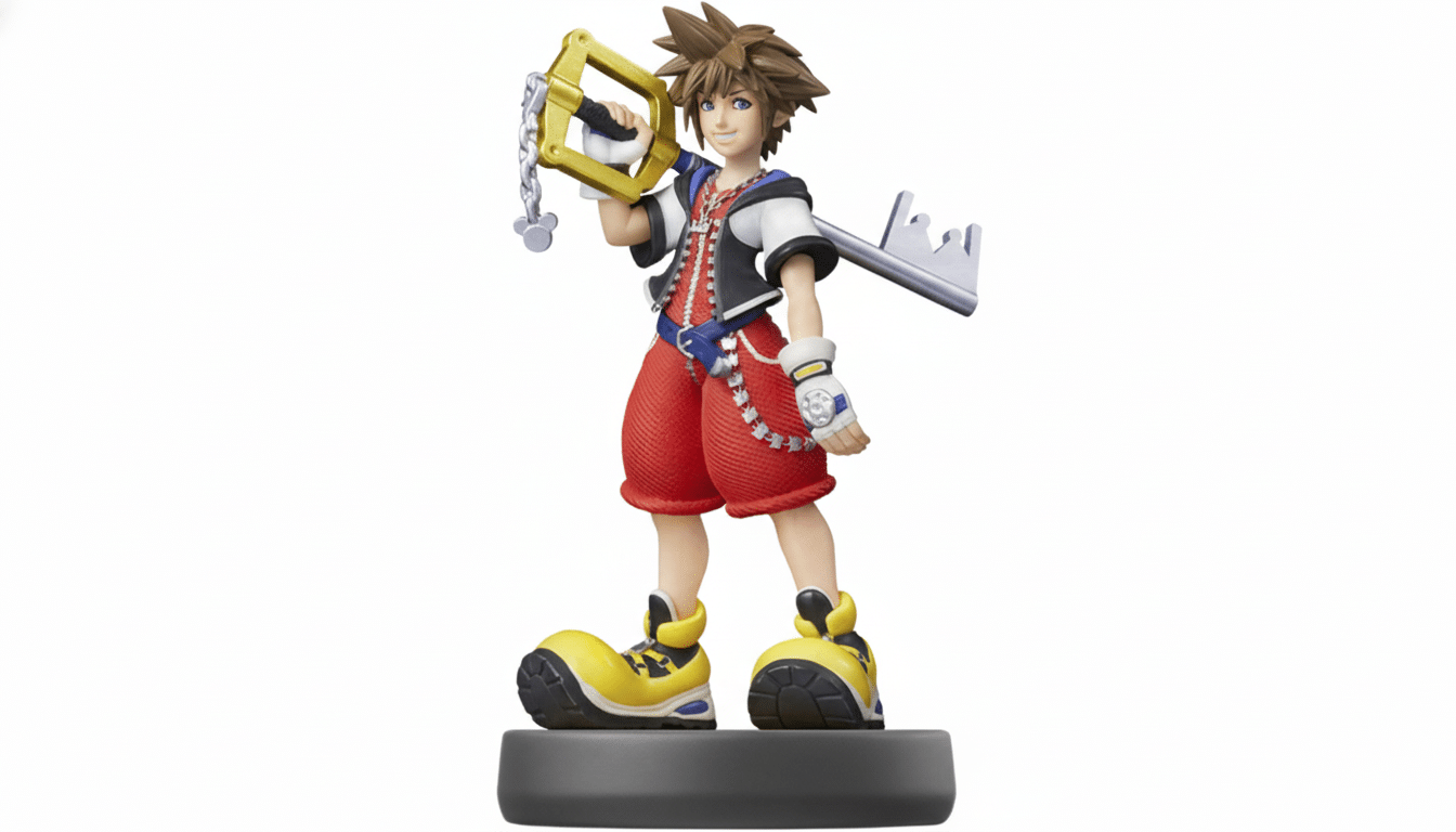 An Ami ibo figure of Sora from Kingdom Hearts, standing on a grey base, holding his Keyblade, against a white background. Filename : sora amiibo1 6x 9. png