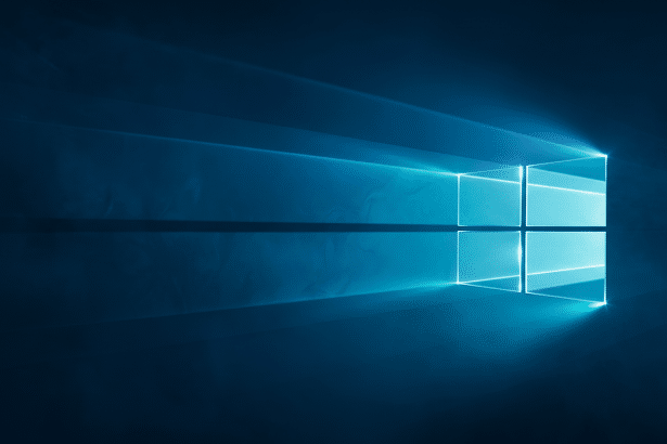 Text : The Windows 10 logo, glowing brightly in shades of blue and cyan , with light rays extending