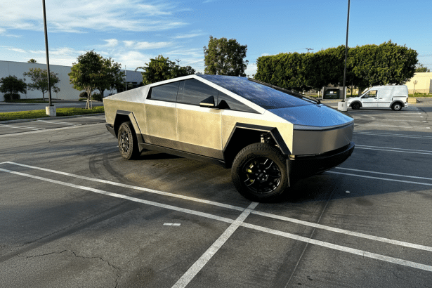 A Tesla Cybertruck parked in an outdoor lot on a sunny day.