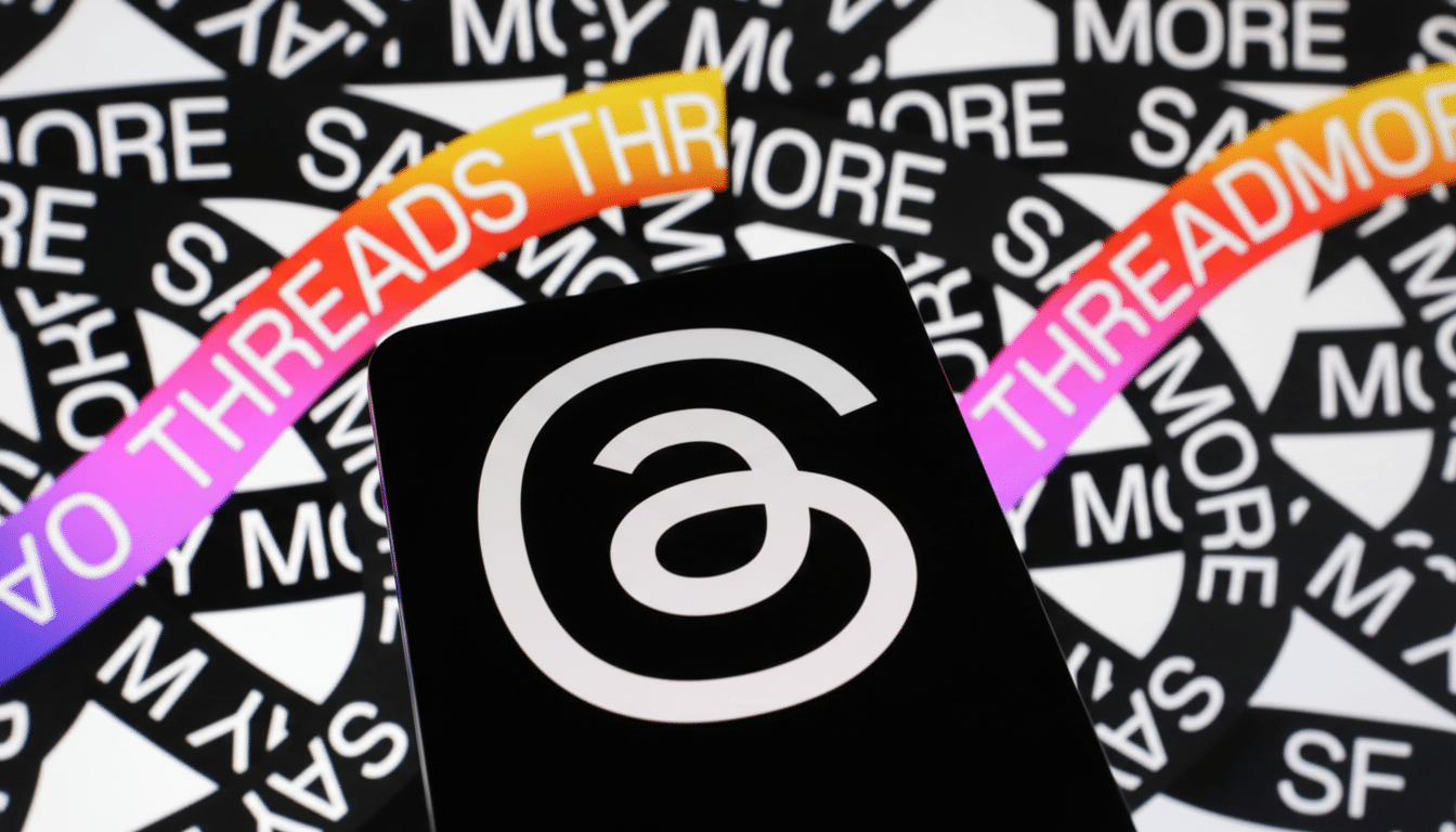 A black smartphone displaying the white Threads logo ( an a with a loop ) against a background patterned with THREADS text in black and white, with colorful gradient accents. Filename : threadslogo smartphone 1 69. png