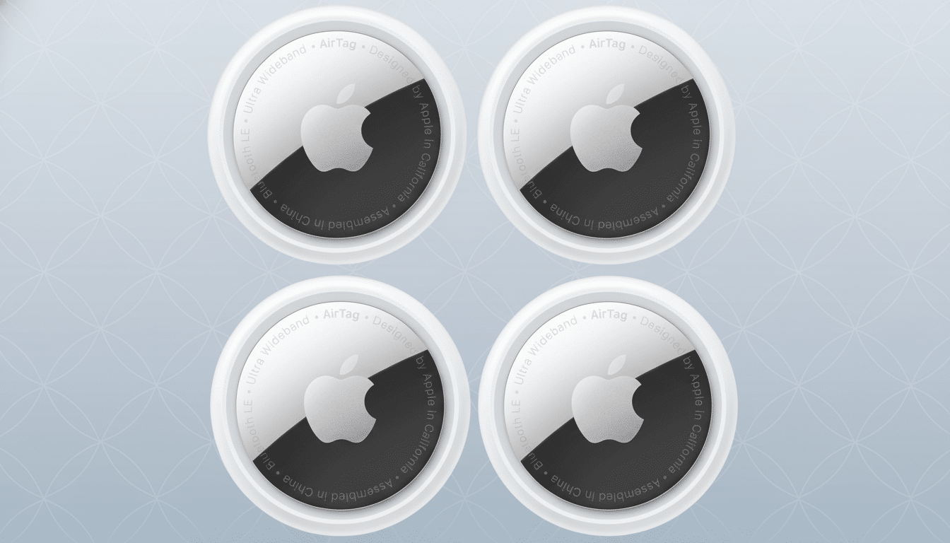 Four Apple AirTags on a professional gray background with a subtle geometric pattern.
