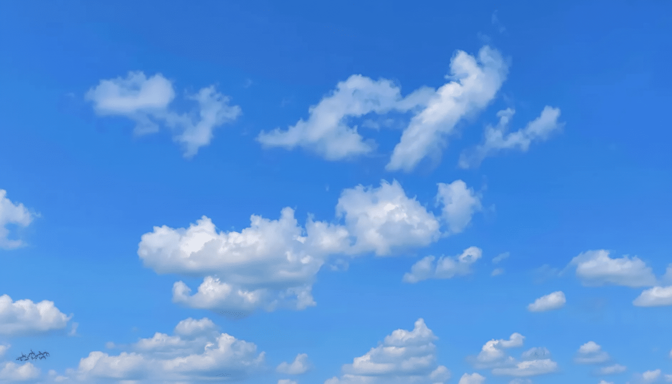 Blue sky with scattered white cum ulus clouds.