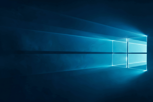 A professional, enhanced image of the Windows logo glowing brightly against a dark blue background with light rays extending to the left, maintaining its original aesthetic and visual impact .