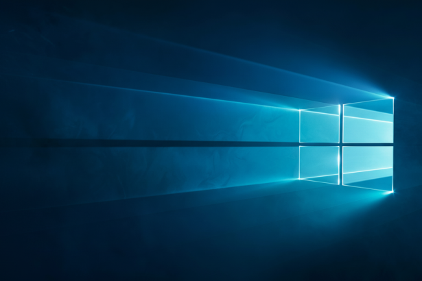 A vibrant blue Windows 10 logo illuminates a dark background , with light rays extending horizontally from the logo ' s right side. Filename : windows1 0logo illumin ateddark background.png