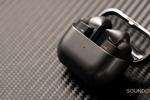 Black wireless earbuds in their open charging case, displayed on a textured dark gray surface. Filename : wireless earbuds case .png