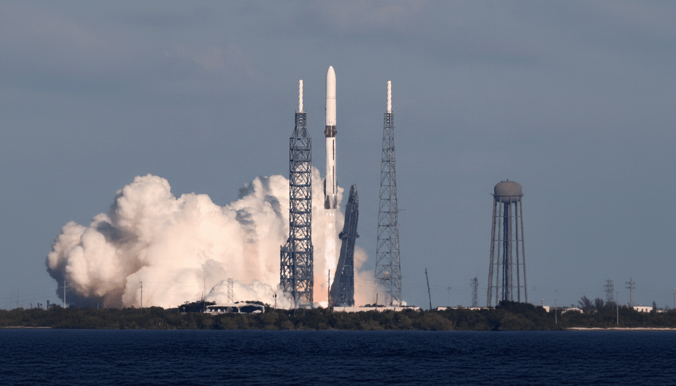 A rocket launching from a launchpad, surrounded by smoke and fire, with a body of water in the foreground and a water tower in the background.