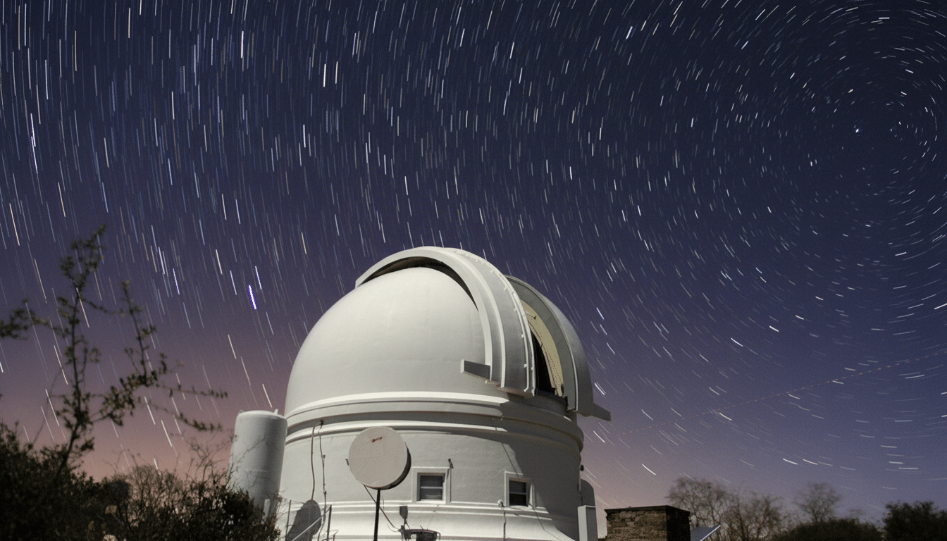 A long exposure photograph of an observatory under a night sky filled with star trails.