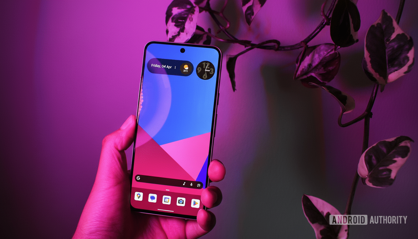 A hand holding a smartphone with a colorful wallpaper, under purple lighting, with a plant in the background.
