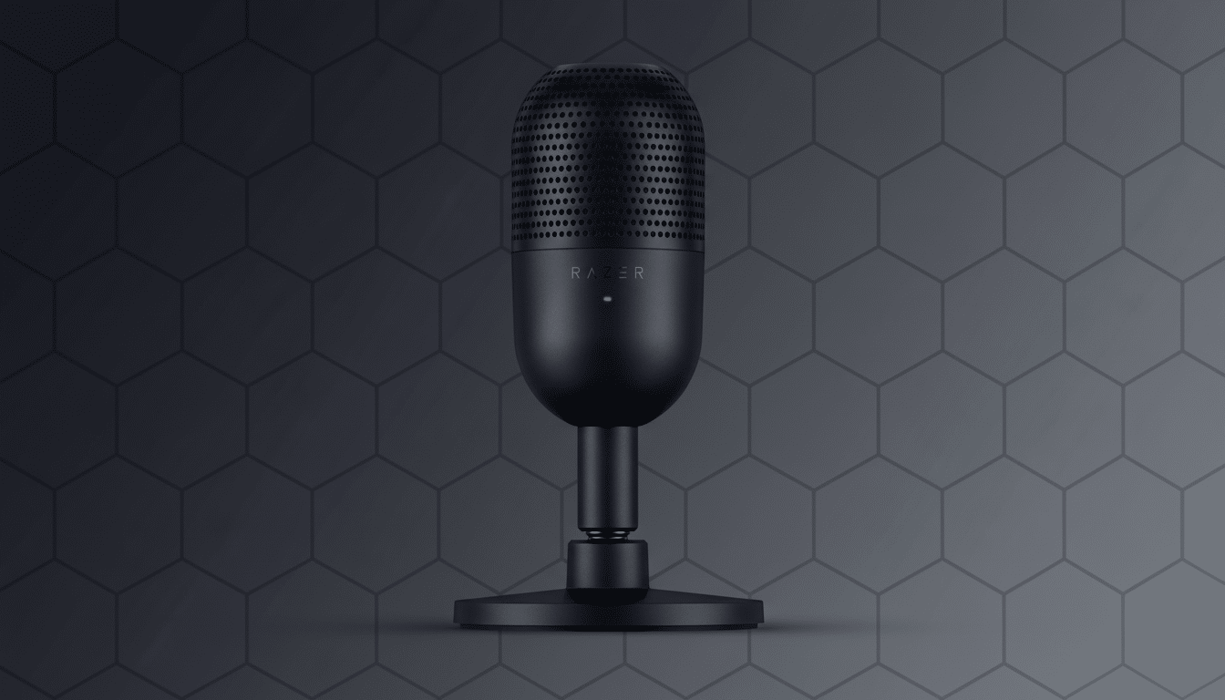 A black Razer Seiren Mini microphone with a green indicator light, set against a dark grey background with a subtle hexagonal pattern.