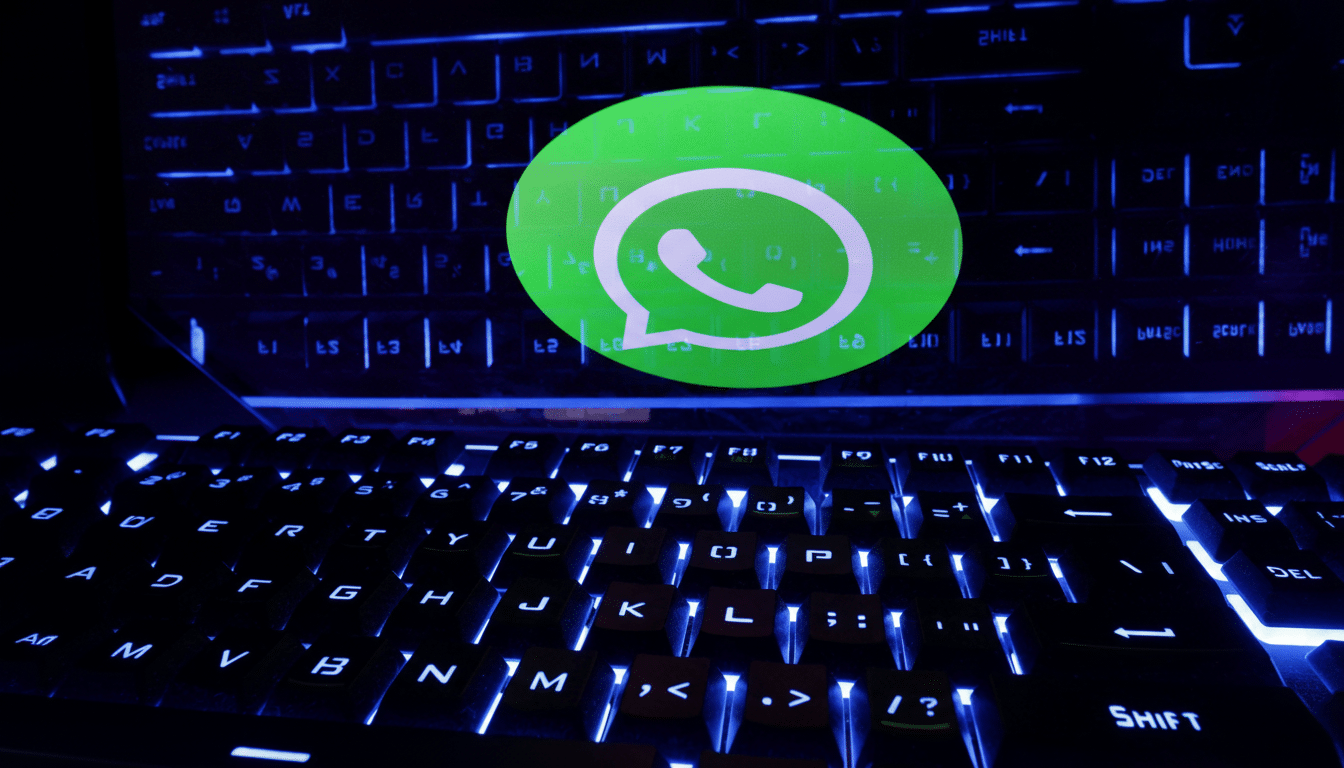 The WhatsApp logo displayed on a screen above a backlit keyboard.