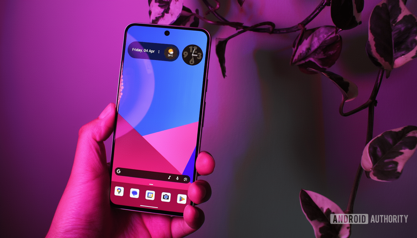 A hand holding a smartphone with a colorful geometric wallpaper, set against a background of green and purple leaves.