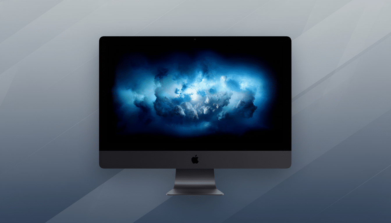 A dark gray iMac Pro with a blue cloud wallpaper on its screen, set against a professional gray background with subtle diagonal patterns.