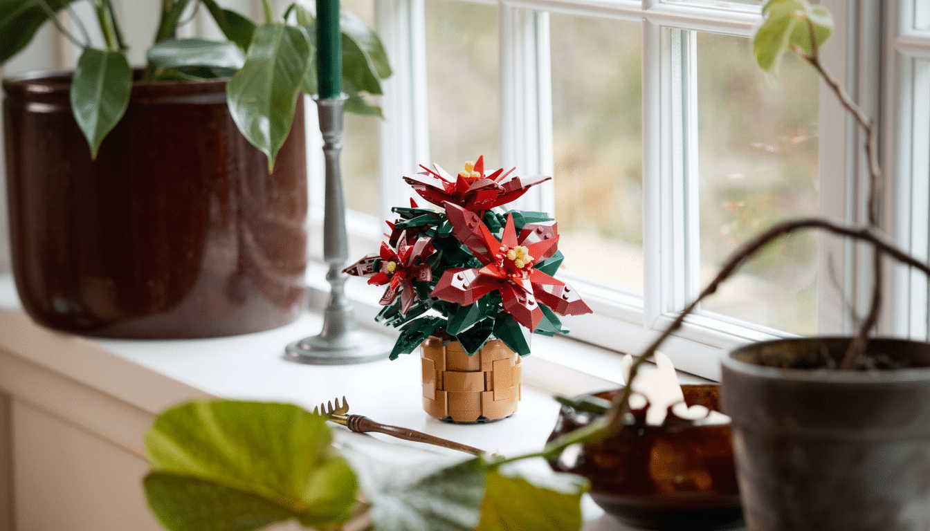 A Lego poinsettia plant in a brown basket sits on a white windowsill, with green plants and a candle holder visible in the background.