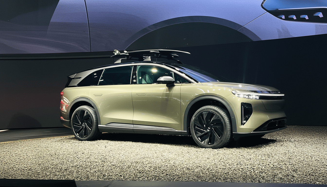 A sleek, modern SUV in a muted green color, with a roof rack carrying what appears to be a surfboard, displayed on a textured grey surface with a dark background and subtle lighting.