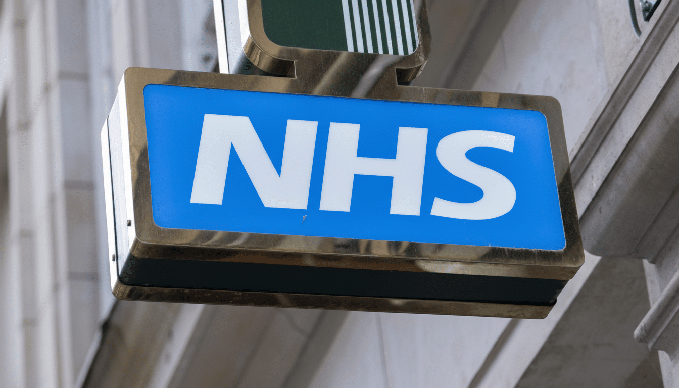 A professionally enhanced image of the NHS logo on a blue sign, resized to a 16:9 aspect ratio, with the original background preserved.